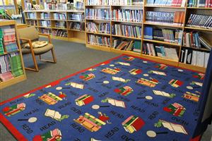 Picture of a rug and books on the shelf in the library 